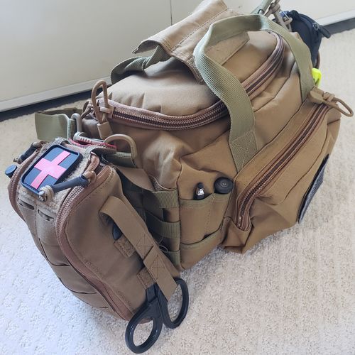 Tactical pouch with various compartments and a flag patch on a light-colored floor.
