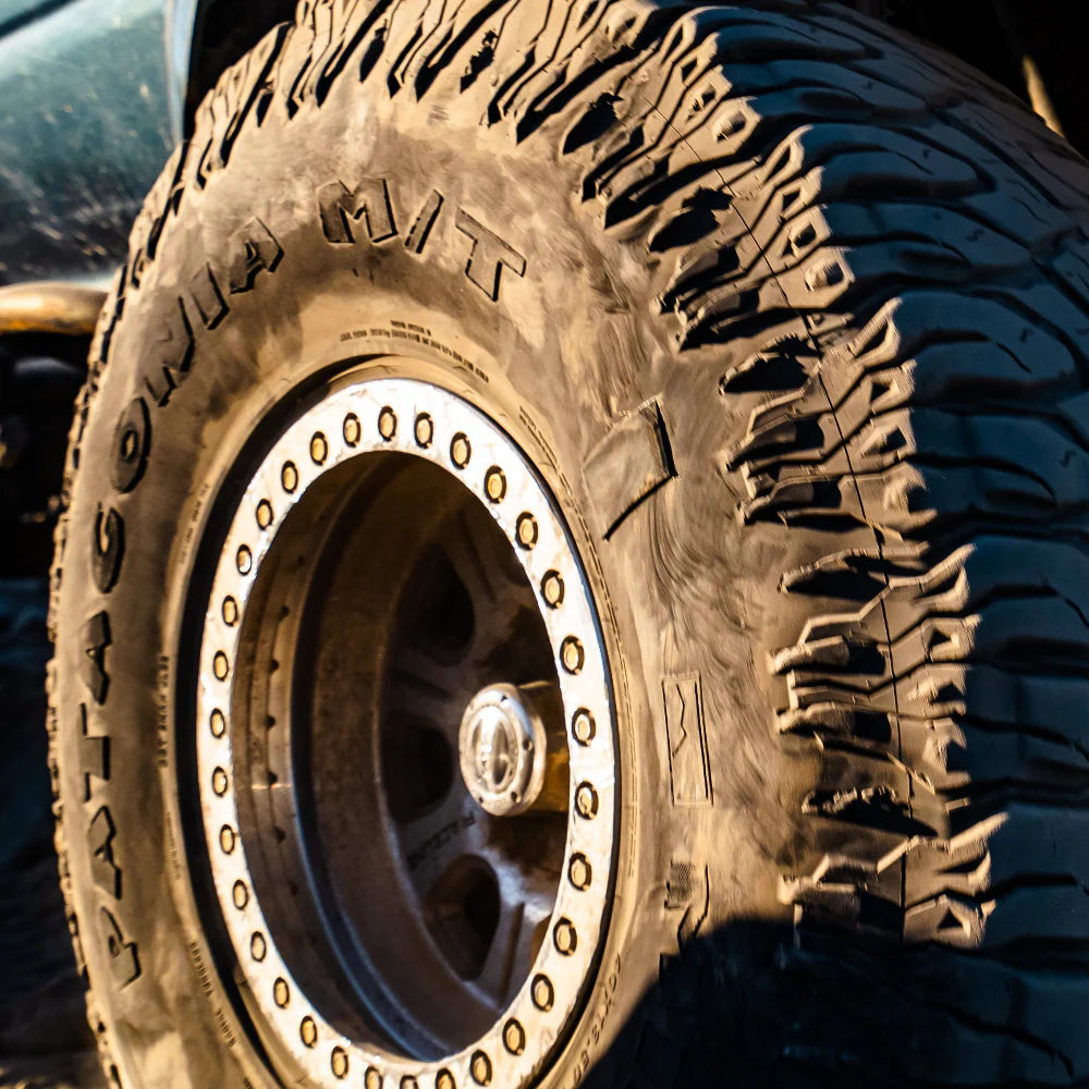 Close-up of a rugged tire with deep treads on a vehicle.