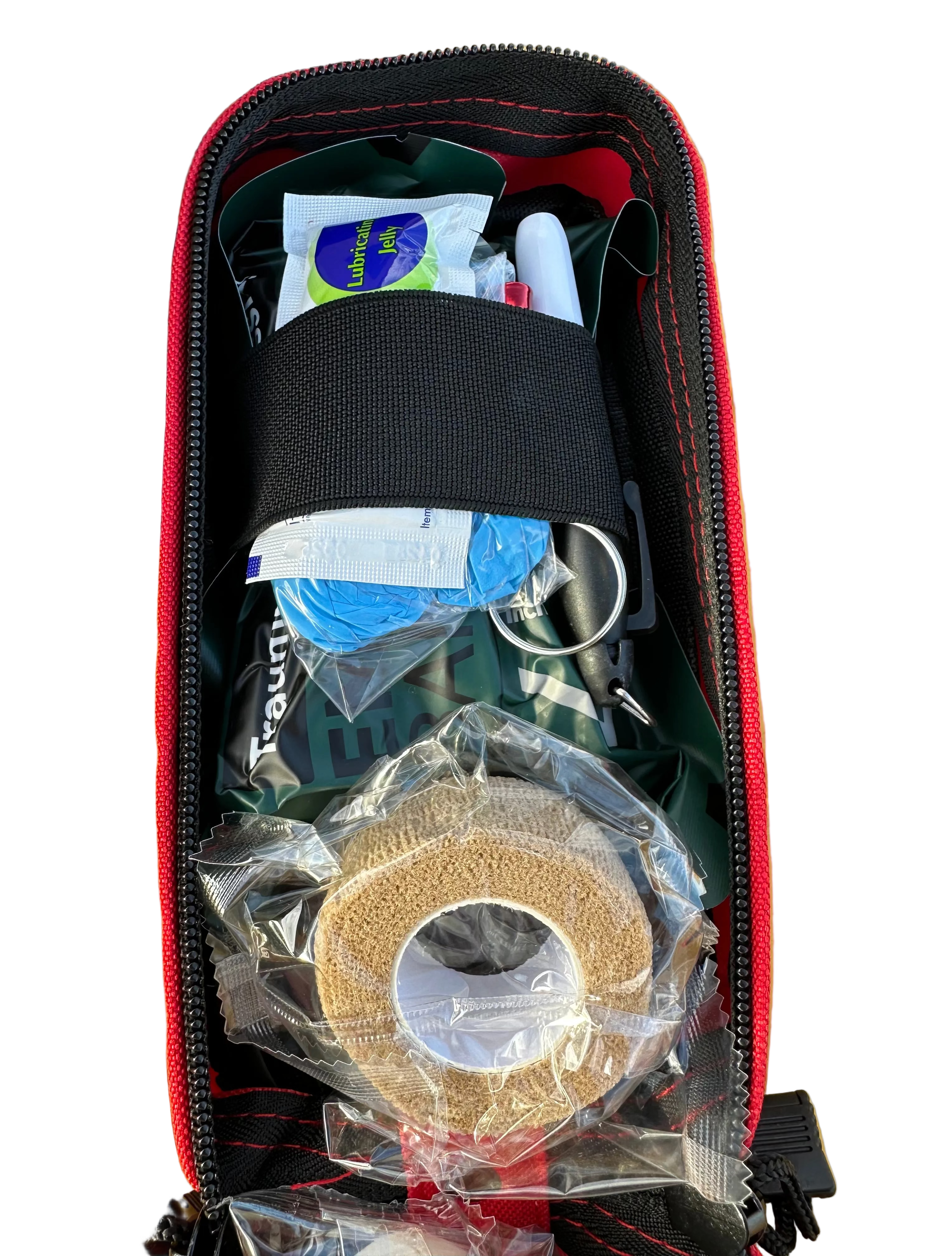 Open ifak case with various items including a roll of sandpaper on a wooden surface