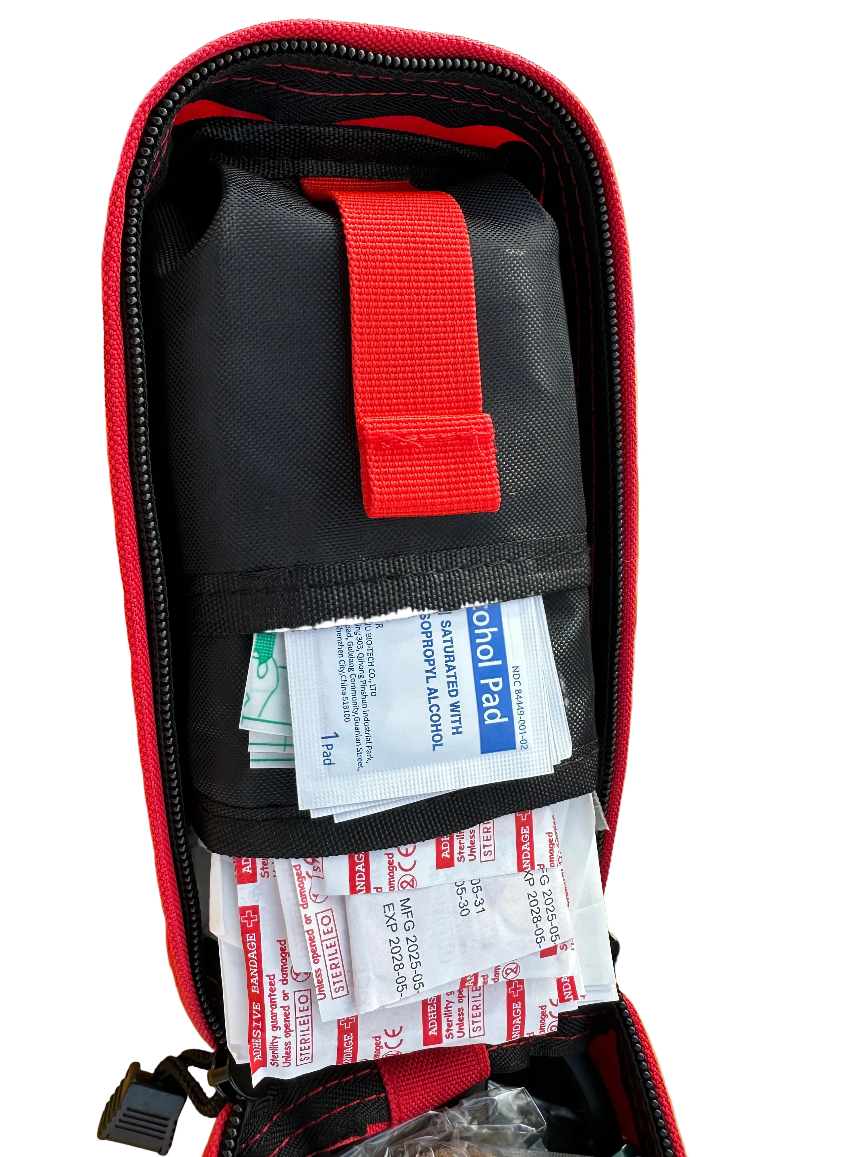 First aid kit with bandages in a red and black case on a yellow surface