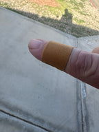 Finger with a finger bandage on a concrete surface