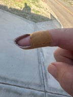 Hand with a bandaged finger outdoors on a road